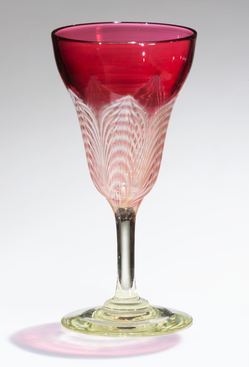 Glass goblet with clear or slightly greenish base and stem, and pattern on body of white and red arcs changing to solid red at top