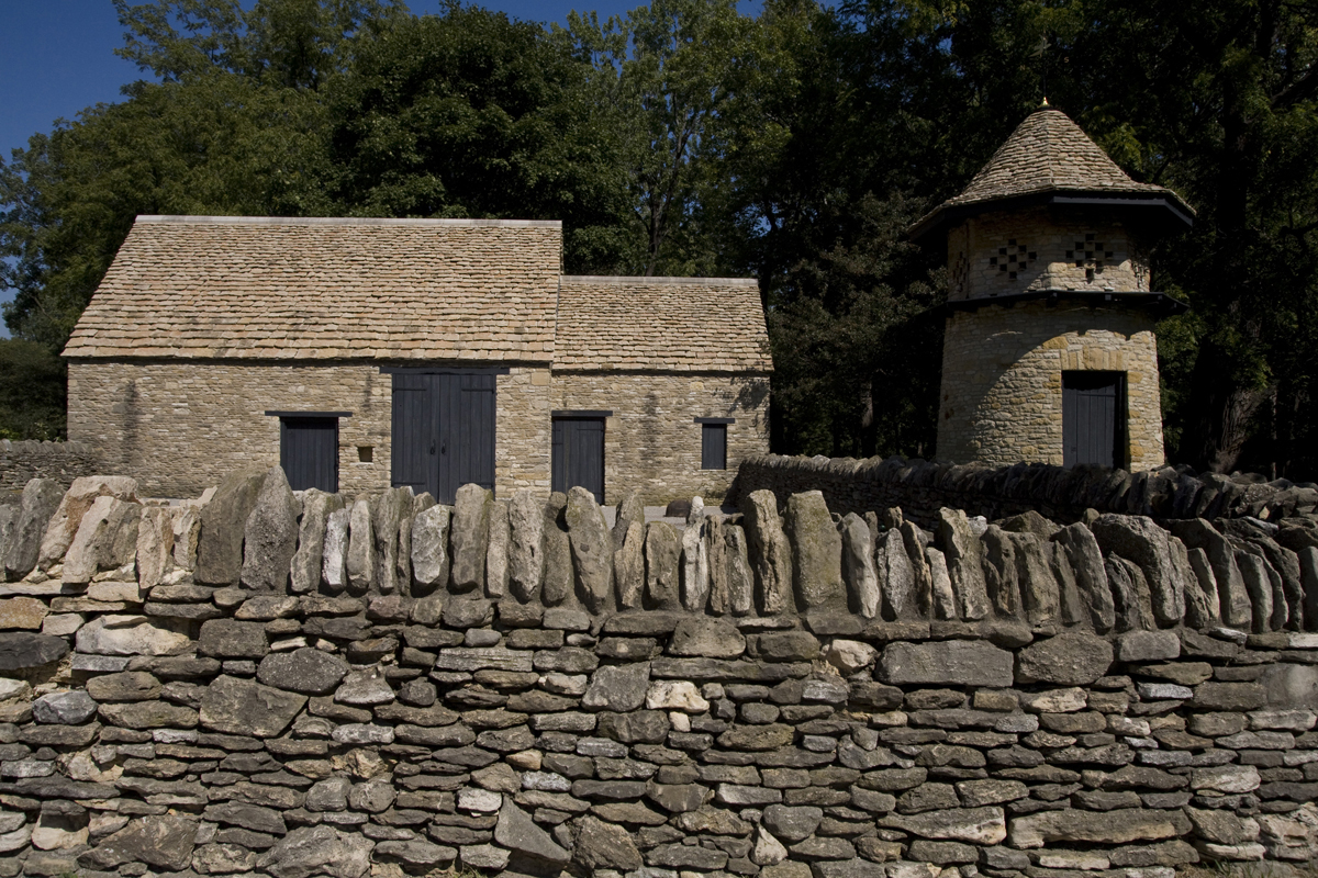 Stone wall with stone building and stone tower visible behind it