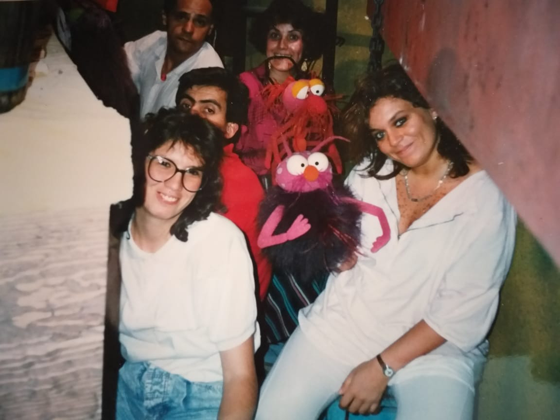 Group of people in tight space, several holding puppets