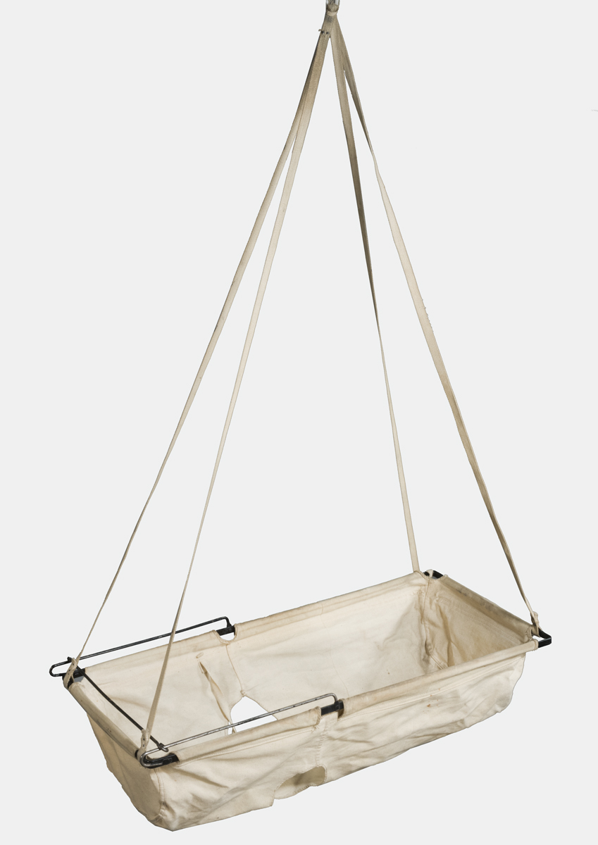 Beige fabric forming a type of hammock, suspended from rectangular frame and four ropes