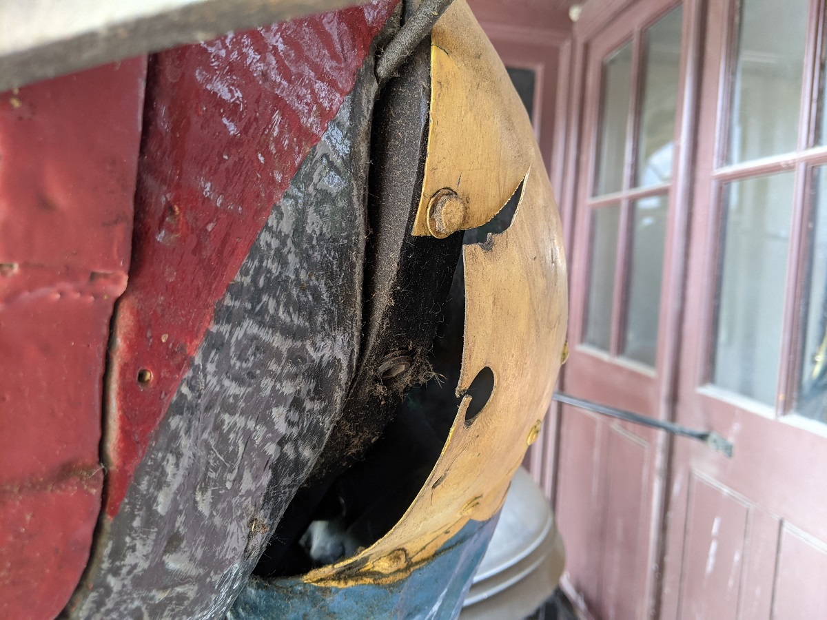 Close-up of shoulder of figure in different colors and textures, one portion damaged