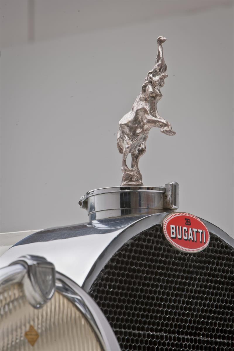 1931 Bugatti Type 41 Royale Convertible / hood ornament Silver hood ornament of elephant standing on his back legs on car hood; black grille and headlight visible