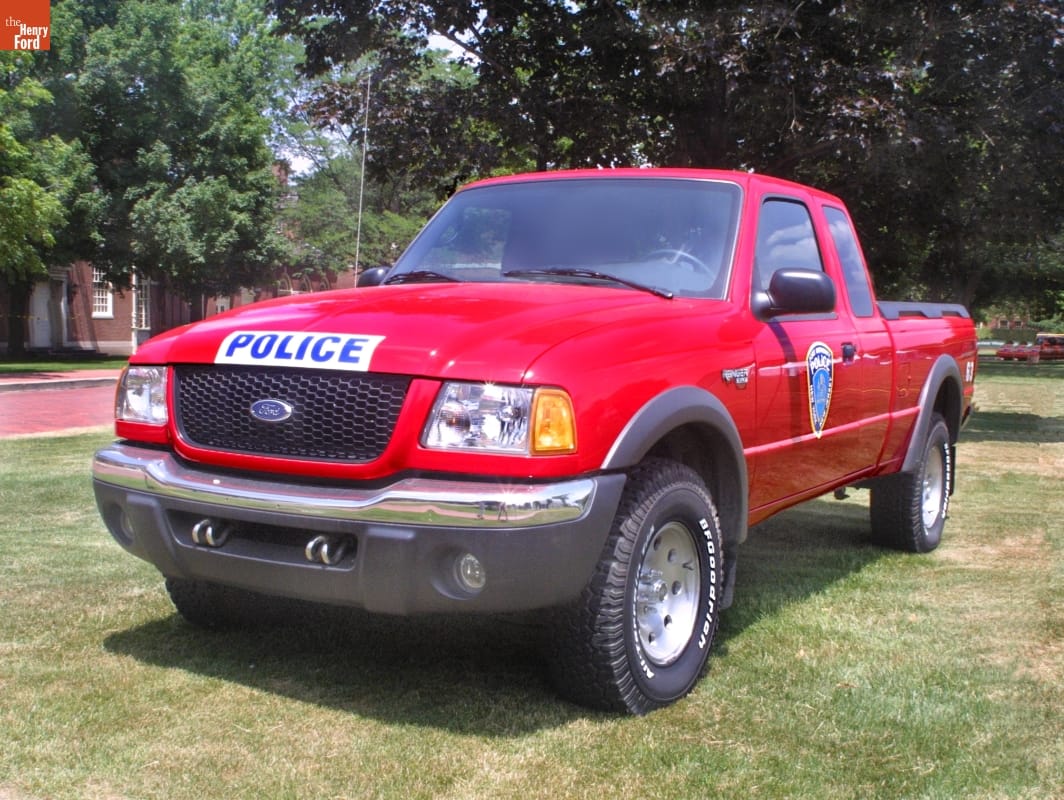 Red pick-up truck with badge on door and text "POLICE" on front of hood