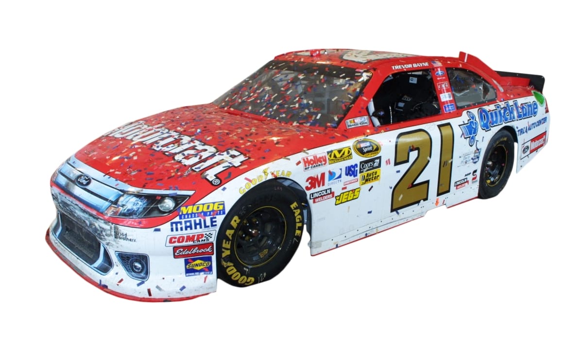 2011 Ford Fusion Stock Car, Driven by Trevor Bayne. On Loan from the Wood Brothers Racing. Red car with white sides with text and logos on all surfaces, covered in confetti