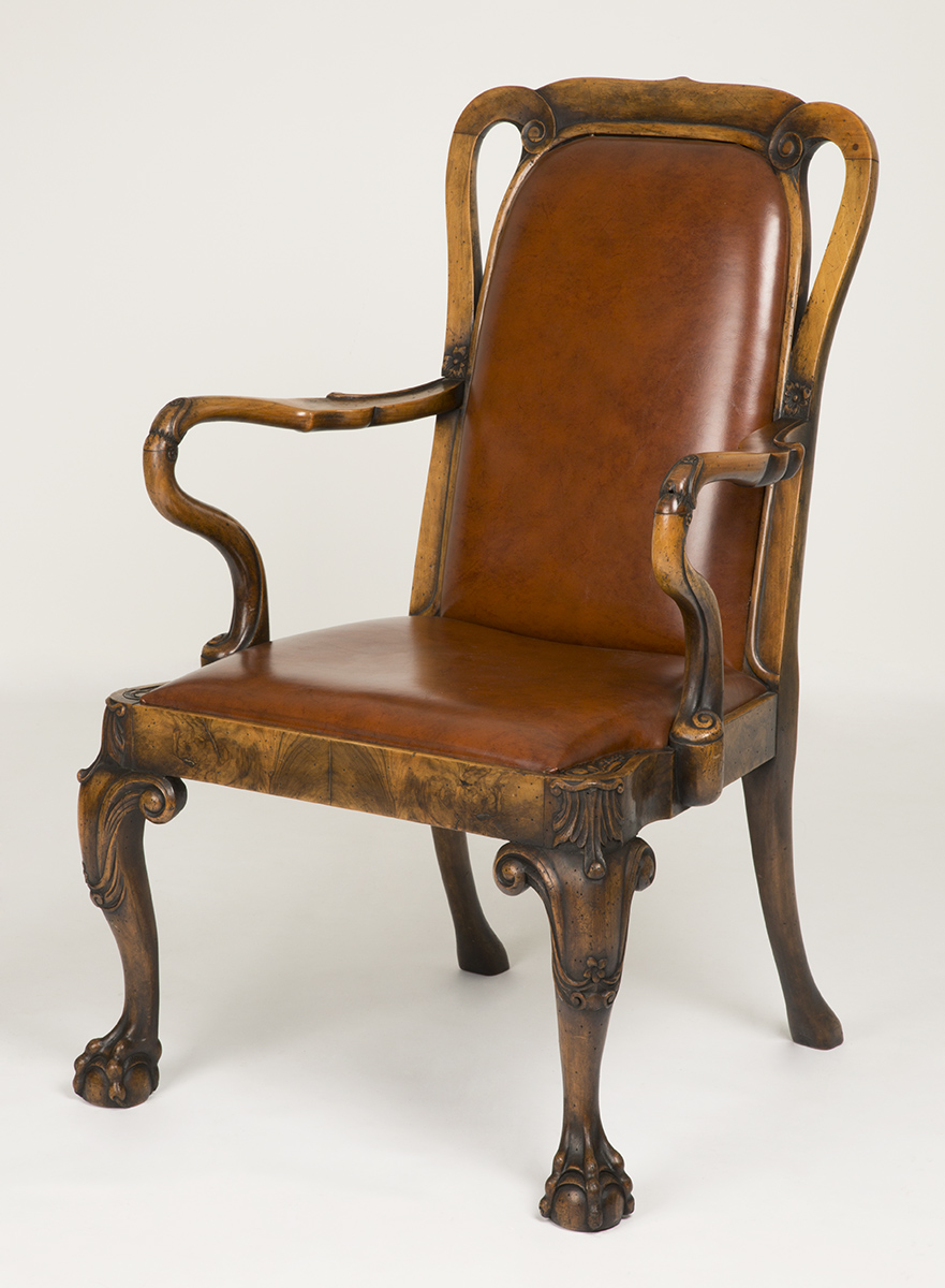 Brown leather chair with wooden legs, arms, and back edging