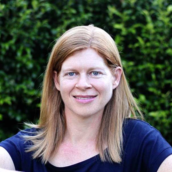 Light-skinned woman with dark blonde hair wearing a blue shirt