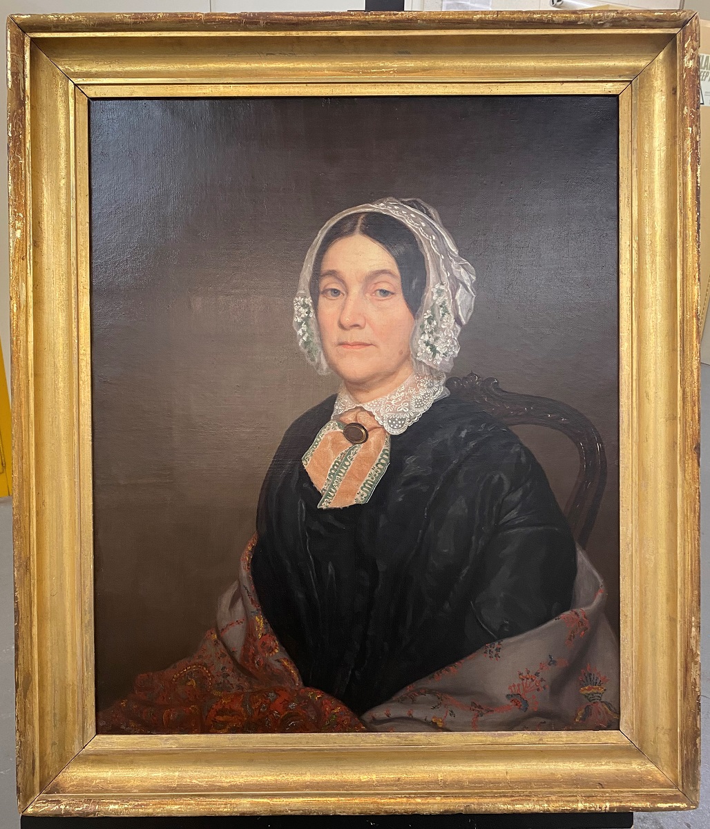 Gold-framed painting of woman in black dress, shawl, and white lace bonnet