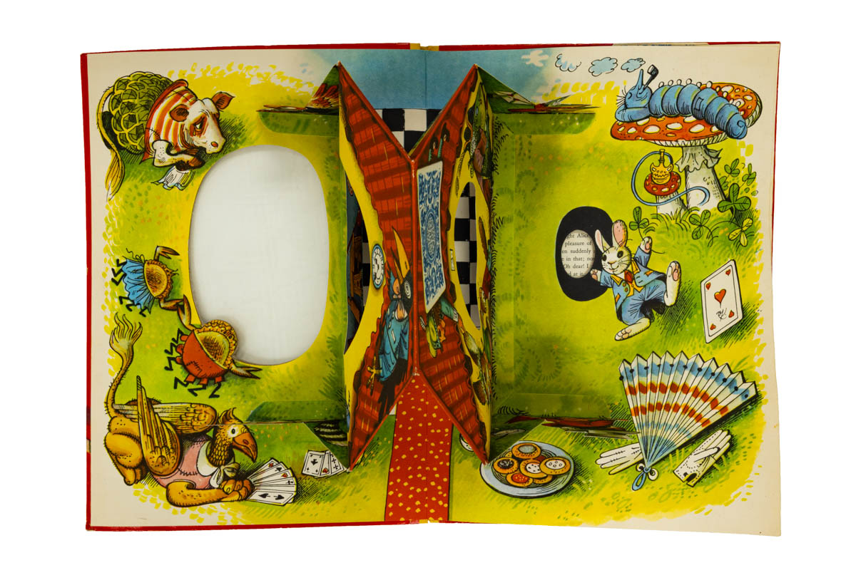 The front pop-up seen from above shows how Kubašta designed the cellophane-covered die-cut to reveal images. Note the large oval on the front cover (left), the oval cutouts in the pop-up house, and the smaller oval on the right (next to the rabbit) showing some of the book's text. /