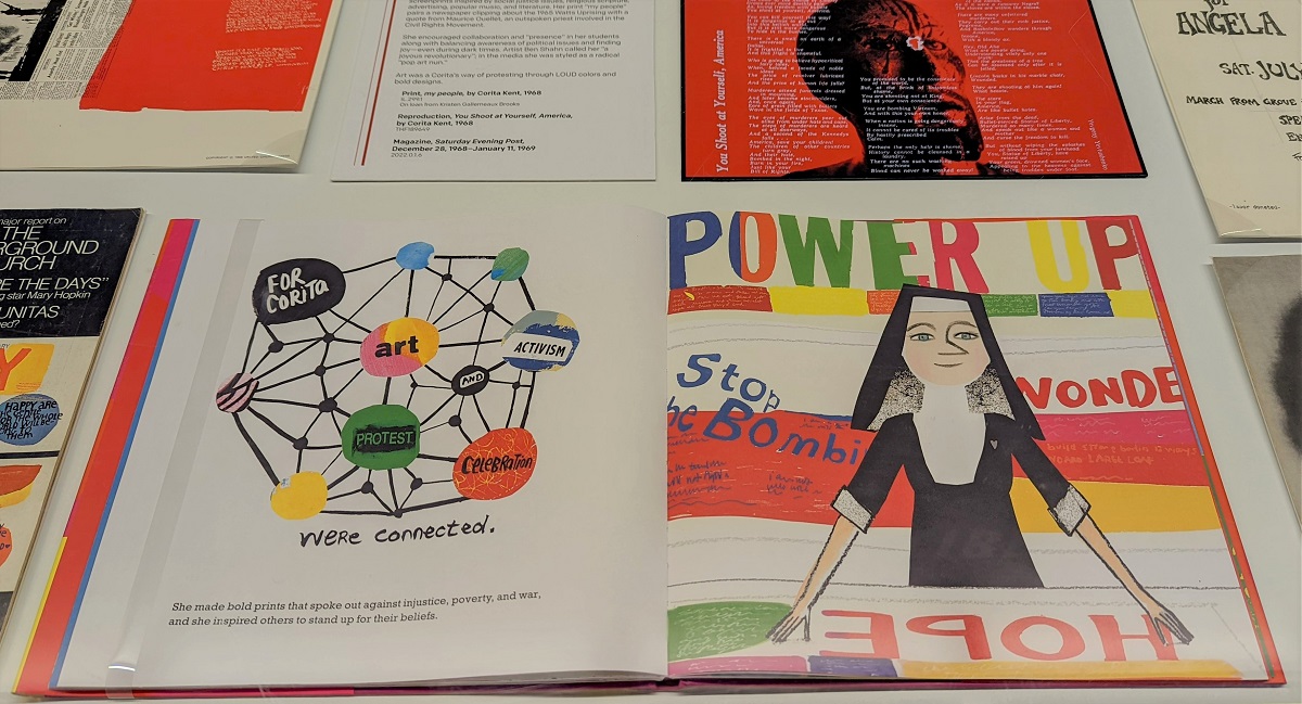 Colorful picture book with text and images open among other material in a display case